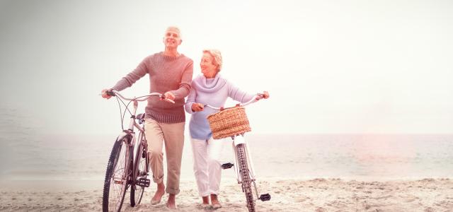 retired couple biking on the beach